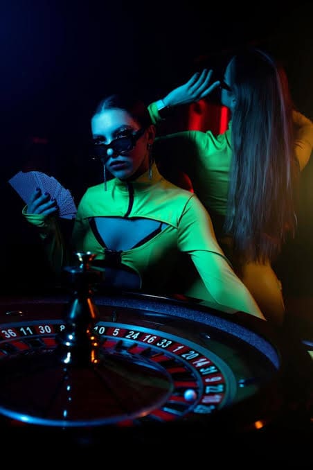 Dwie osoby w teatralnym świetle przy stole ruletki podczas wieczoru tematycznego